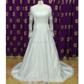 Robe de mariée princesse en dentelle décolleté bijou et manches longues